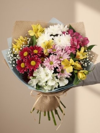 Букет от хризантеми, алстромерии и гипсофила в жълти, розови и бели нюанси, опакован в зебло с канапена панделка.