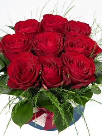 червени рози аранжирани със зеленина в луксозна кутия